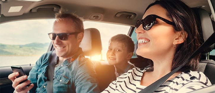 Smiling family in car with phone-1